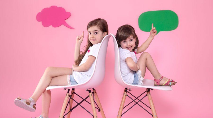 two-little-girls-colored-wall-with-speech-icons-scaled-qqm1zuchu43qf8o6qbjsn9x396srvtwehozjjme3rc